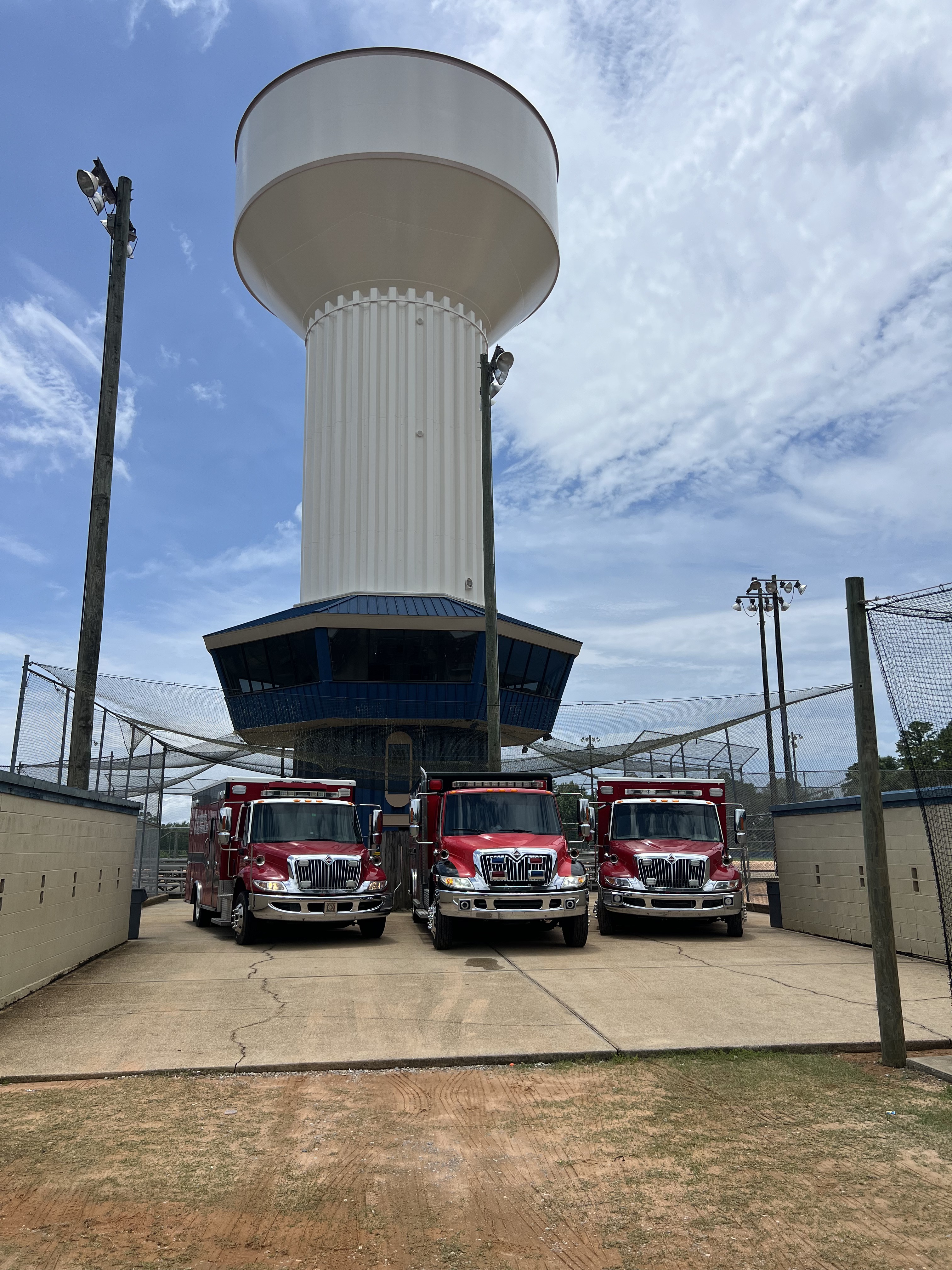 Three Air Medics HVAC trucks lined up under a water tower