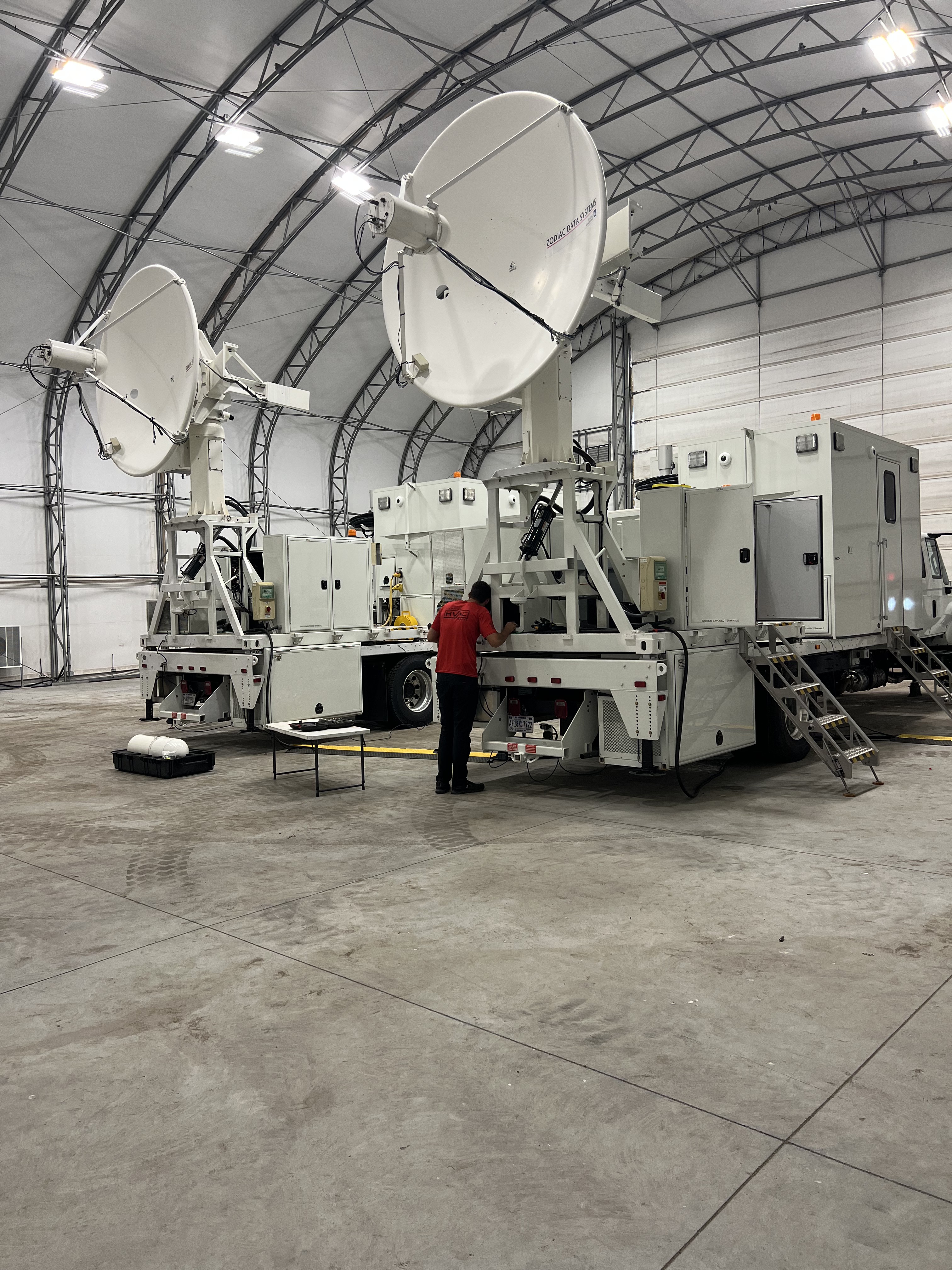 Air Medics tech with commercial vehicles in a warehouse